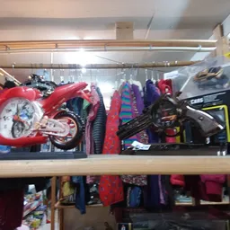 Stellingkast met speelgoed waaronder rode motorfiets, zwarte auto en diverse kleurrijke items