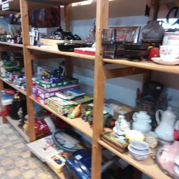 Houten stellingen met huishoudelijke artikelen, servies, borden en overige kringloopwaar