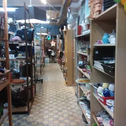Winkelinterieur met stellingen vol tweedehands spullen langs een smalle gang