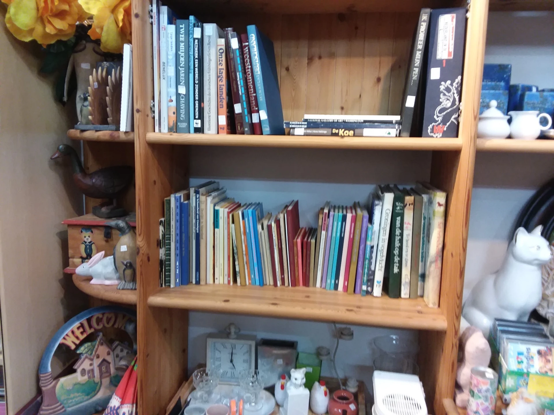 Houten boekenkast met dvd's, cd's en boeken op drie niveaus, met huishoudelijke artikelen