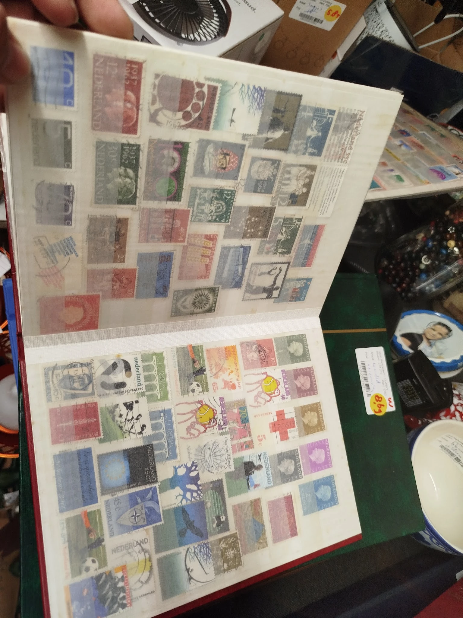 Verzameling losse postzegels uit verschillende landen en periodes, gerangschikt in een fotoalbum