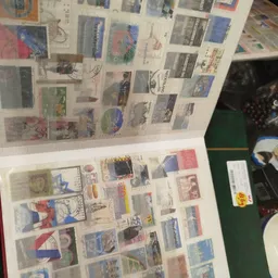Postzegels en ansichtkaarten uitgestald in verzamelalbums