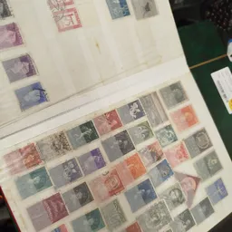 Verzameling van postzegels uit verschillende landen en periodes, gerangschikt in een album