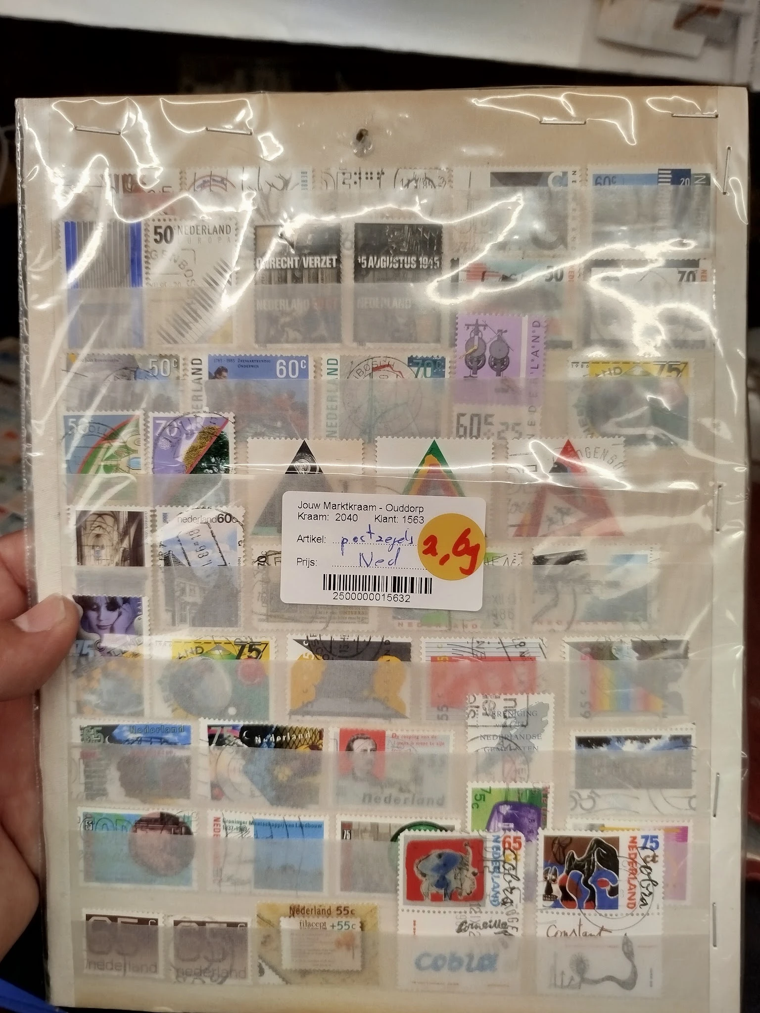 Verzameling postzegels en filateliearticula in een sorteerbox met prijskaartjes