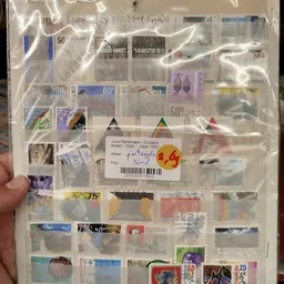 Verzameling postzegels en filateliearticula in een sorteerbox met prijskaartjes