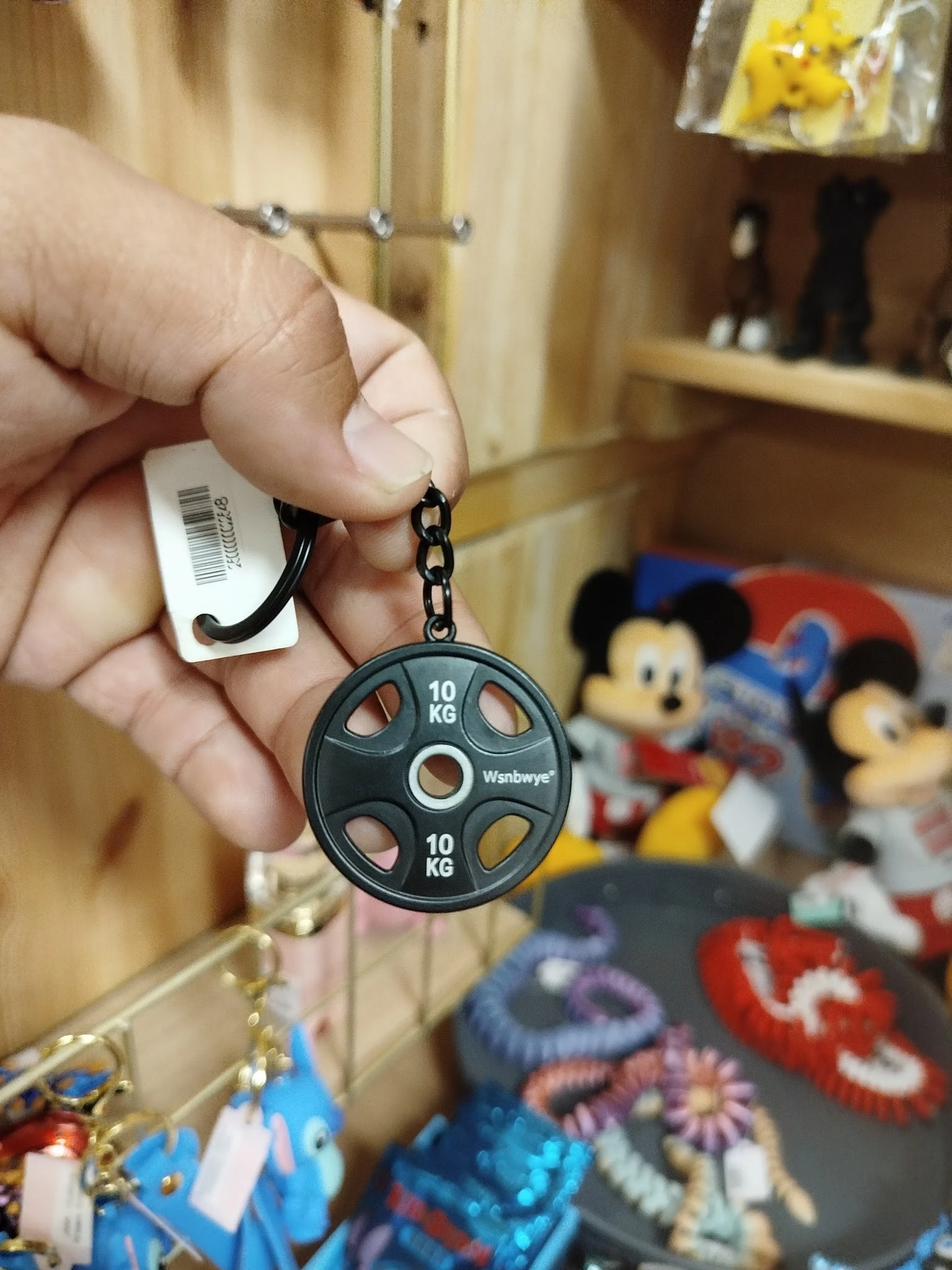Sleutelhanger in vorm van schijf met gewichtsaanduidingen, met prijskaartje eraan