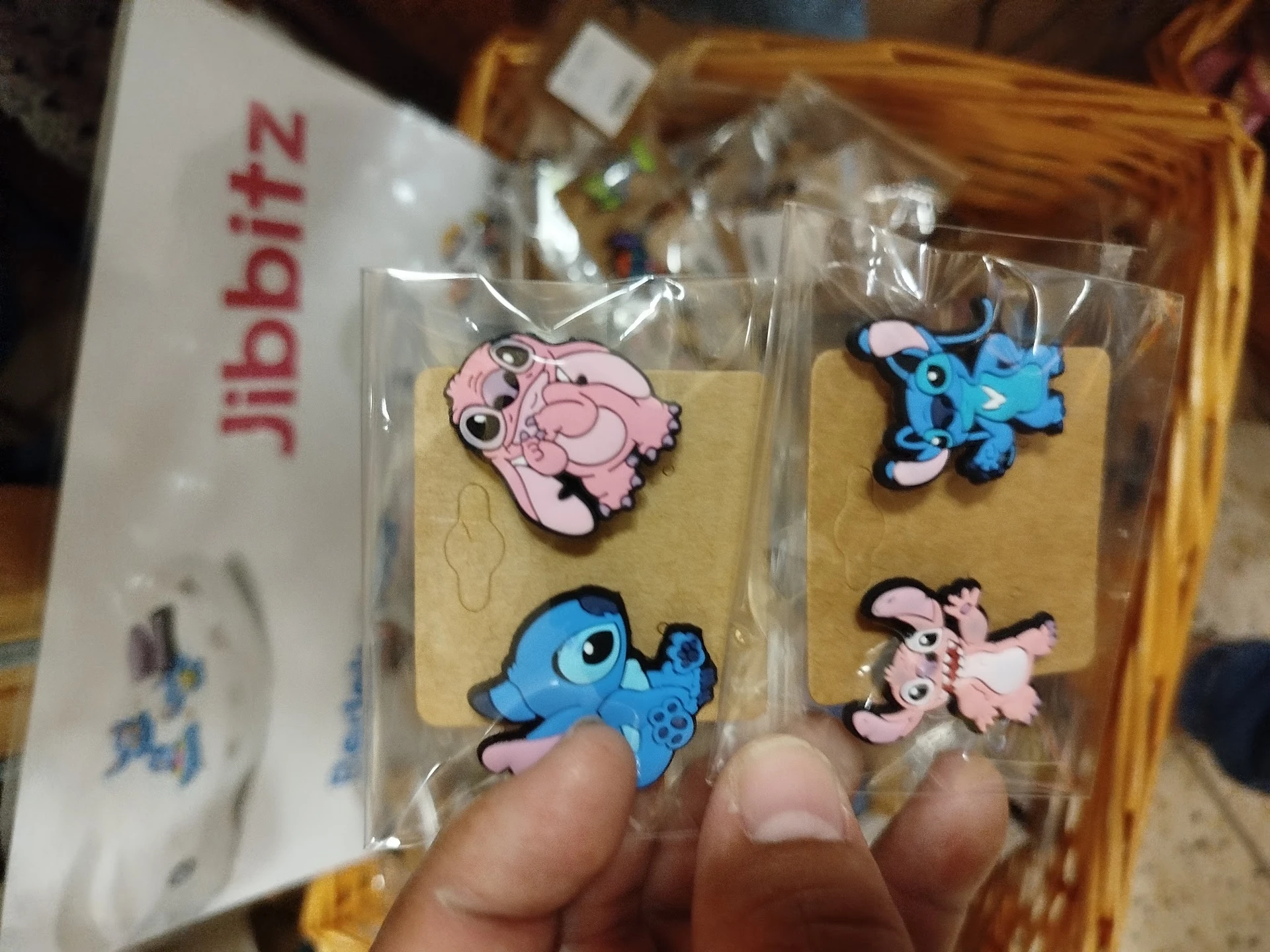 Close-up van vier gekleurde kinderhangers in roze en blauw met dierenvormen, verpakt in plastic op kartonnen kaartjes