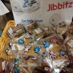 Uitgestalde kinderspeelgoed en actiefiguren in plastic zakjes op een tafel in de winkel
