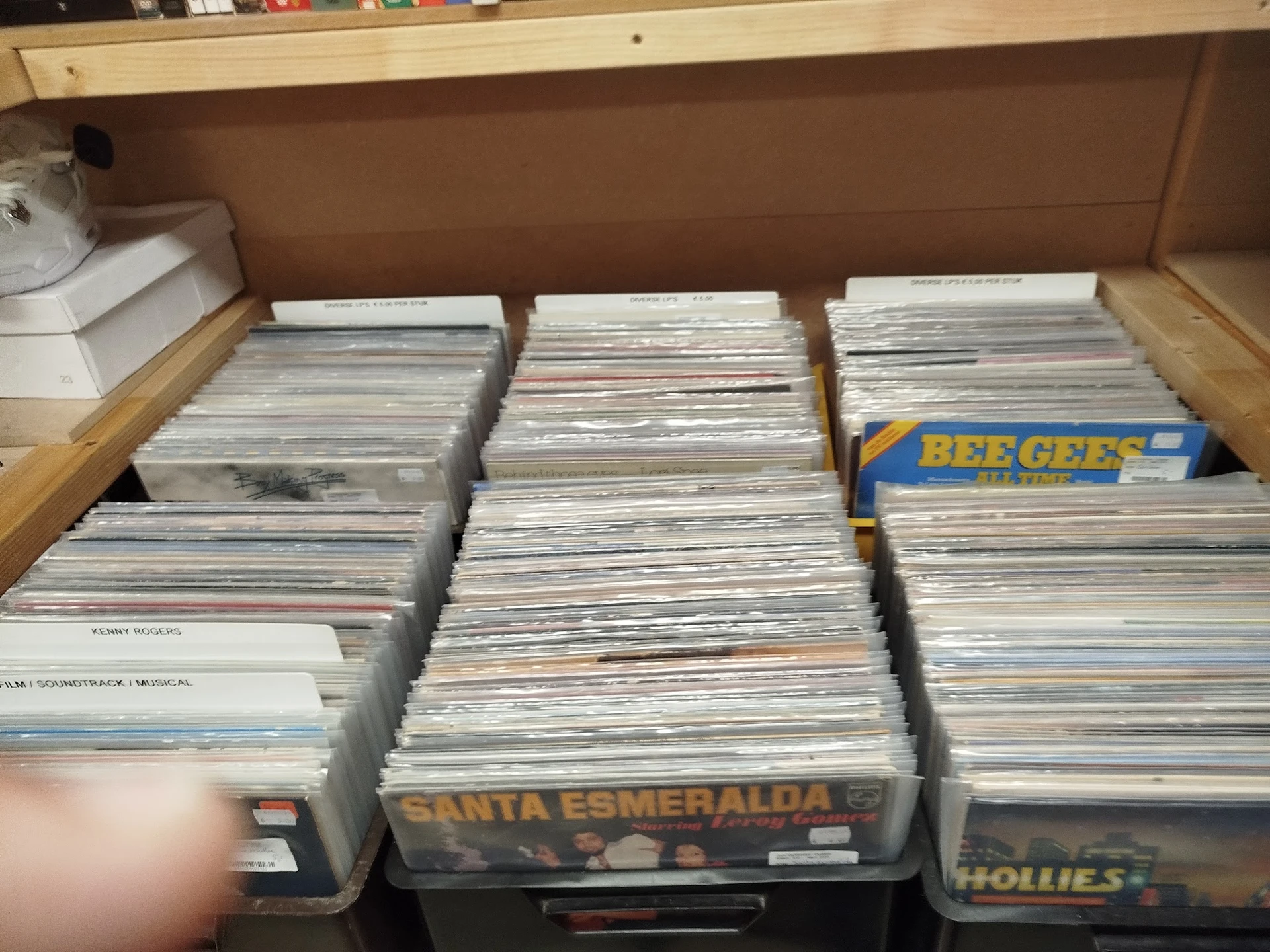 Drie bakken met grote hoeveelheid cd's en dvd's, waaronder zichtbaar 'Santa Esmeralda' en 'Bee Gees'