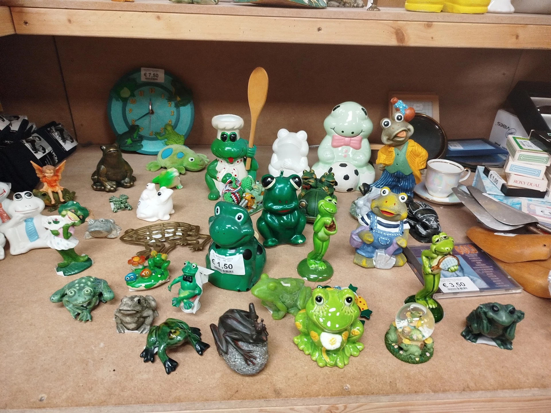 Verzameling groene en witte decoratieve beeldjes en speelgoed uitgestald op een plank