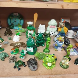 Verzameling groene en witte decoratieve beeldjes en speelgoed uitgestald op een plank