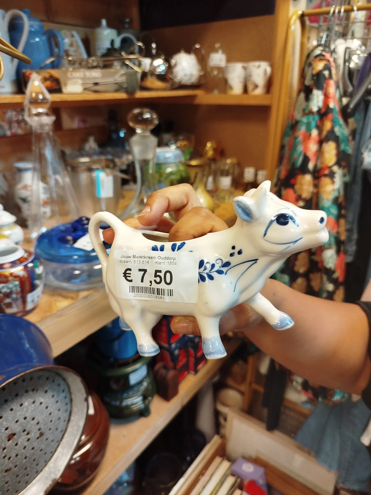 Wit porseleinen koeienbeeldje met blauw decoratie en prijskaartje van €7.50, gevuld met broodjes