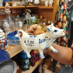 Wit porseleinen koeienbeeldje met blauw decoratie en prijskaartje van €7.50, gevuld met broodjes
