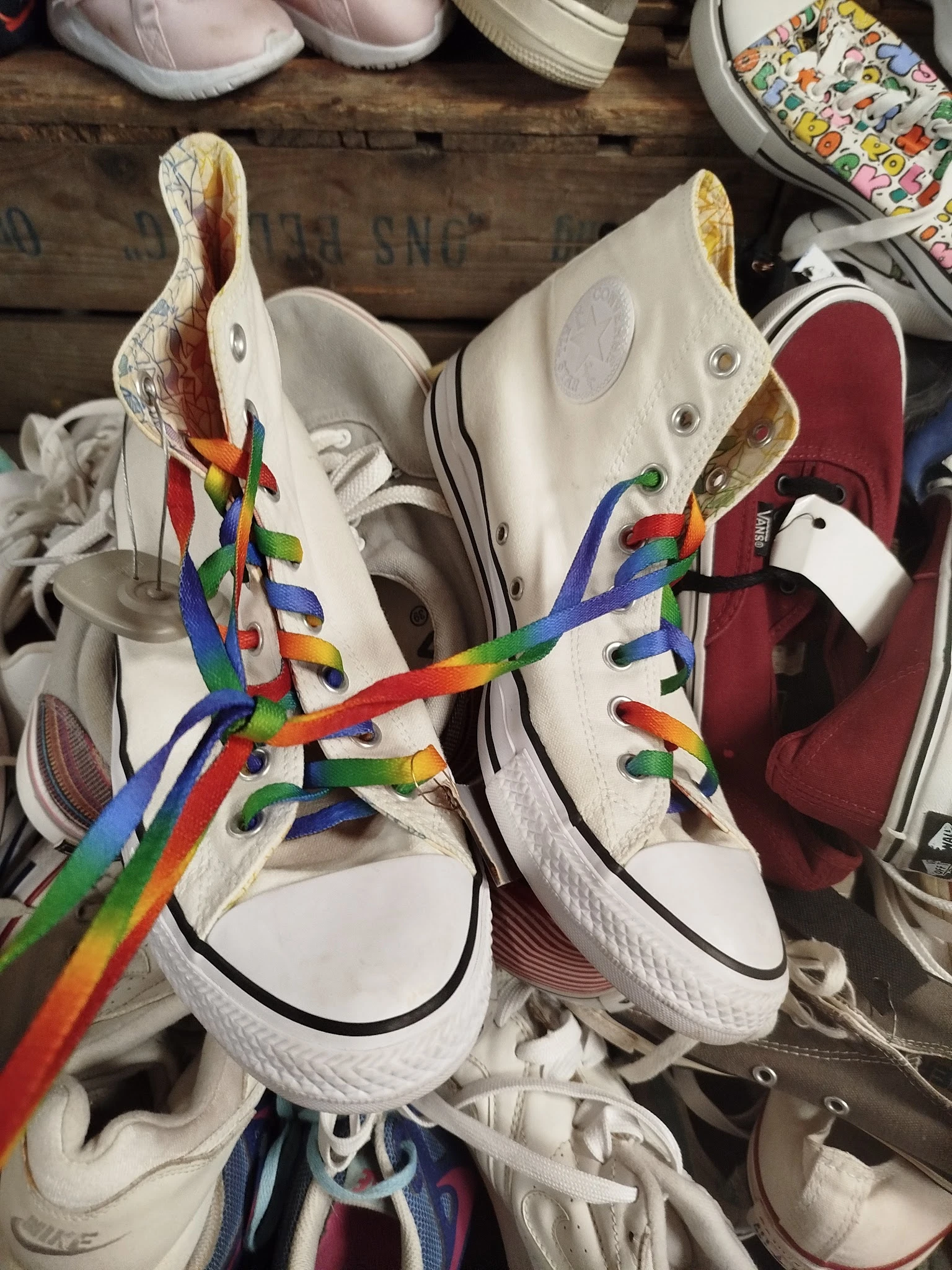Twee witte sneakers met regenboog gekleurde veters, close-up van schoenenpaar