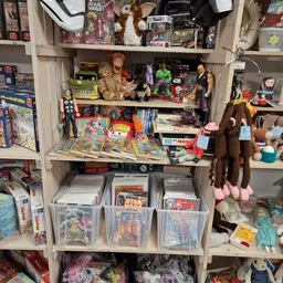 Kasten vol verzameld speelgoed, stripboeken, poppen en actiefiguren in de kringloopwinkel