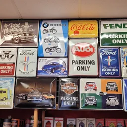 Wandbord-collectie met vintage auto- en motormerken zoals Ford, BMW, Audi, Harley-Davidson, Coca-Cola en Fendt