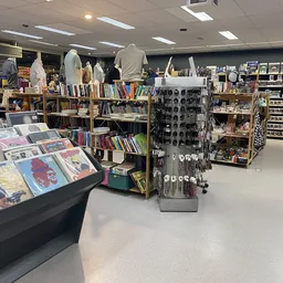 Winkelvloer met rekken, stellingen en uitgestalde tweedehands spullen waaronder boeken, kleding en accessoires