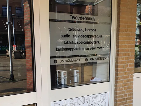 Winkelruit met informatiebord over tweedehandsartikelen en contactgegevens van Jouw2dekans