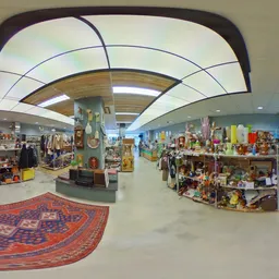 Ruim winkelinterieur met stellingen vol spullen, overhead skylight-verlichting en een rood tapijt op de vloer