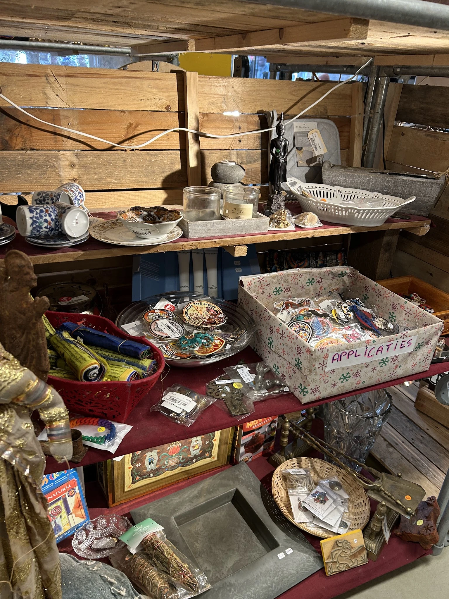 Tweedehands huishoudelijke spullen en decoratieartikelen op tafels, waaronder servies, applicaties en diverse voorwerpen