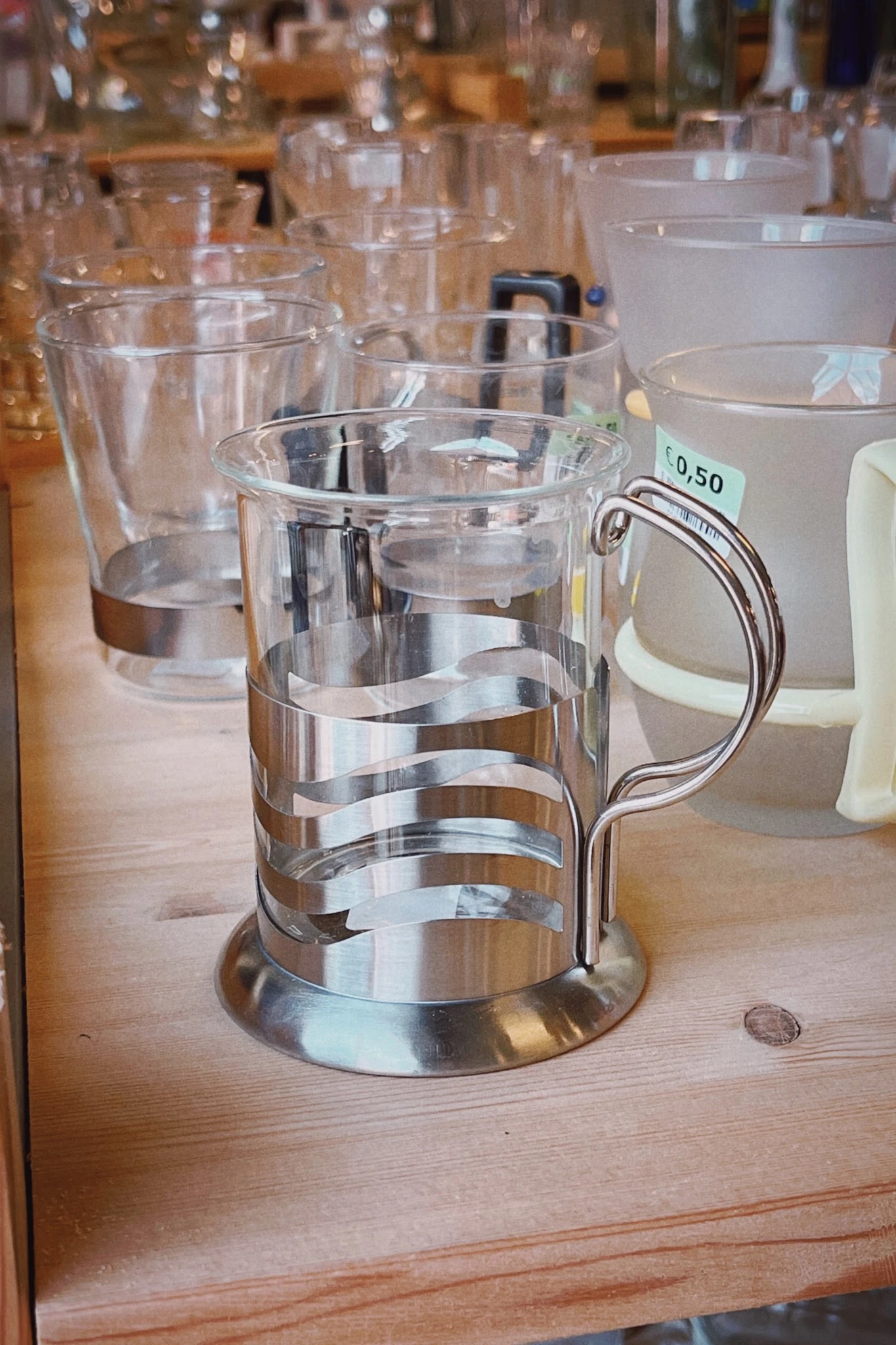 Close-up van een glazen bierpul met zilvergrijze bandjes en een handvat