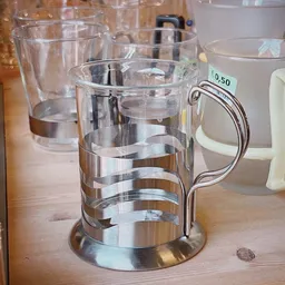 Close-up van een glazen bierpul met zilvergrijze bandjes en een handvat