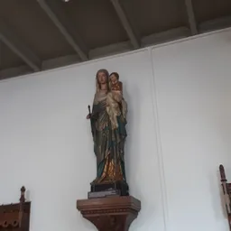 Gekleurde houten beeldengroep van Maria met kind tegen witte wand