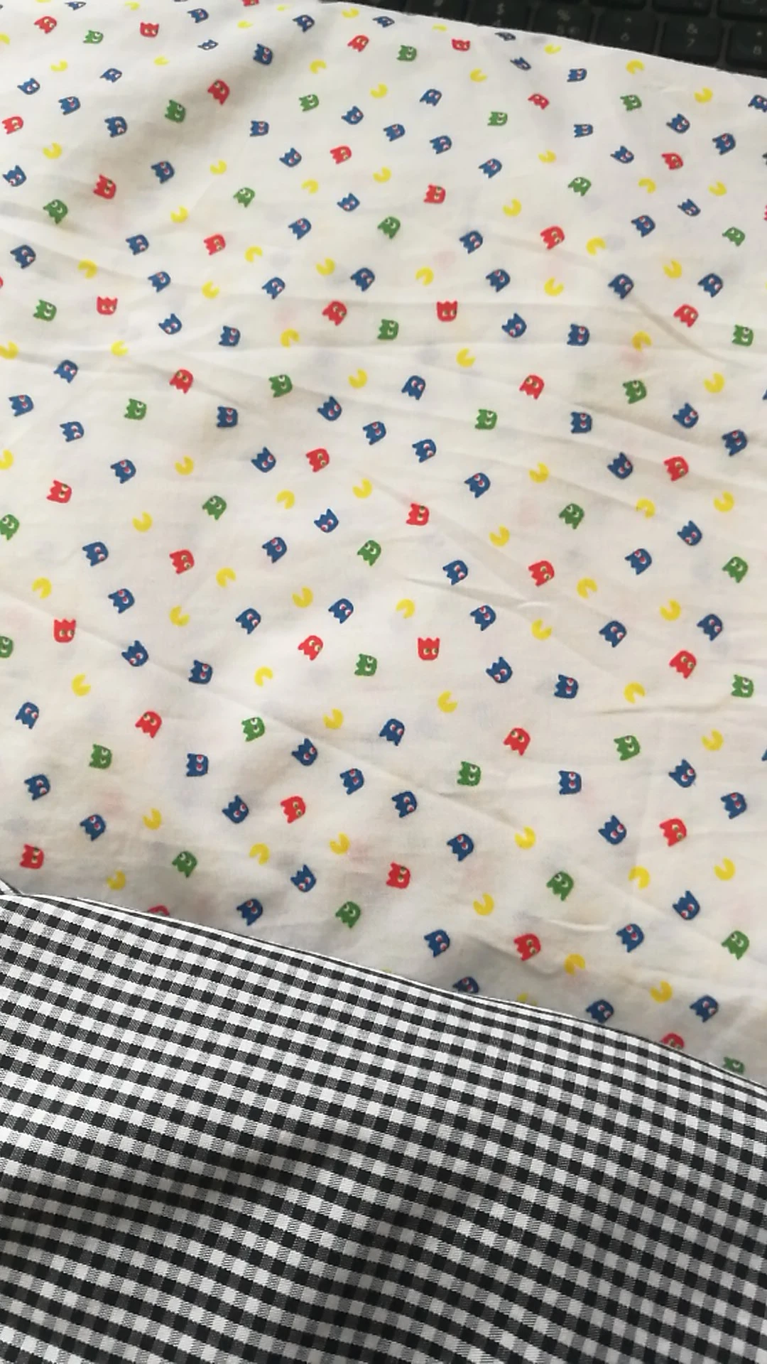 Stof met kindermotief in blauw, rood, groen en geel op een wit achtergrond