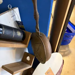 Close-up van een vintage bruine leren schoen met gaatjespatroon, hangend aan een touw