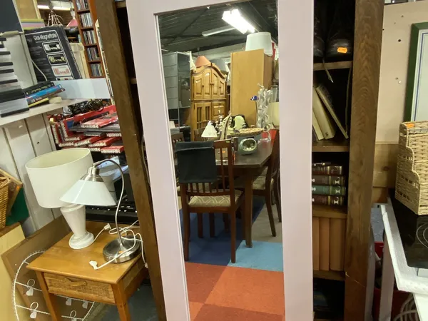 Binnenaanzicht van kringloopwinkel met stellingen, diverse spullen en een gekleurde vloer