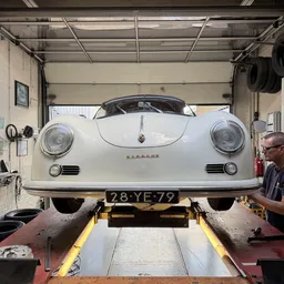 Witte Porsche 356 Speedster op werkbank in garage, frontale close-up met kenteken 28-YE-79