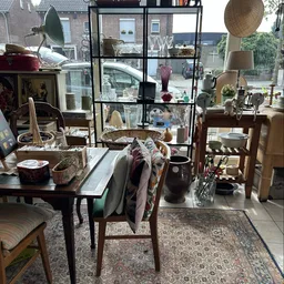 Winkelvloer met diverse tweedehandsartikelen: meubels, lampen, servies en decoraties uitgestald