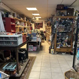 Winkelvloer van kringloopwinkel met stellingen vol spullen, muziekinstrumenten en diverse artikelen