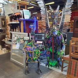 Uitgestalde decoratieve artikelen met kleurige verlichtingskabels en siervoorwerpen in een kringloopwinkel
