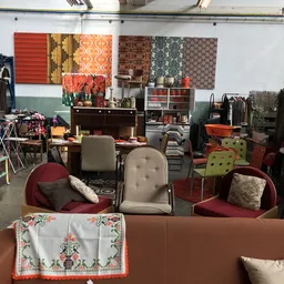 Winkelinterieur met meubels, stoelen, kleding en huisraadgoederen op displays en rekken