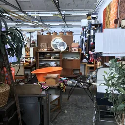 Winkelvloer van kringloopwinkel met meubels, huishoudartikelen en decorstukken uitgestald