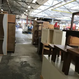 Winkelvloer met kastjes, tafels en diverse meubelstukken uitgestald in een kringloopwinkel