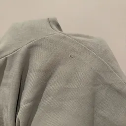 Close-up van een beige/grijze gebreide trui of sweater met textuur