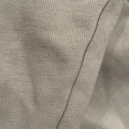 Close-up van beige/grijze gebreide stof met ribbelstructuur