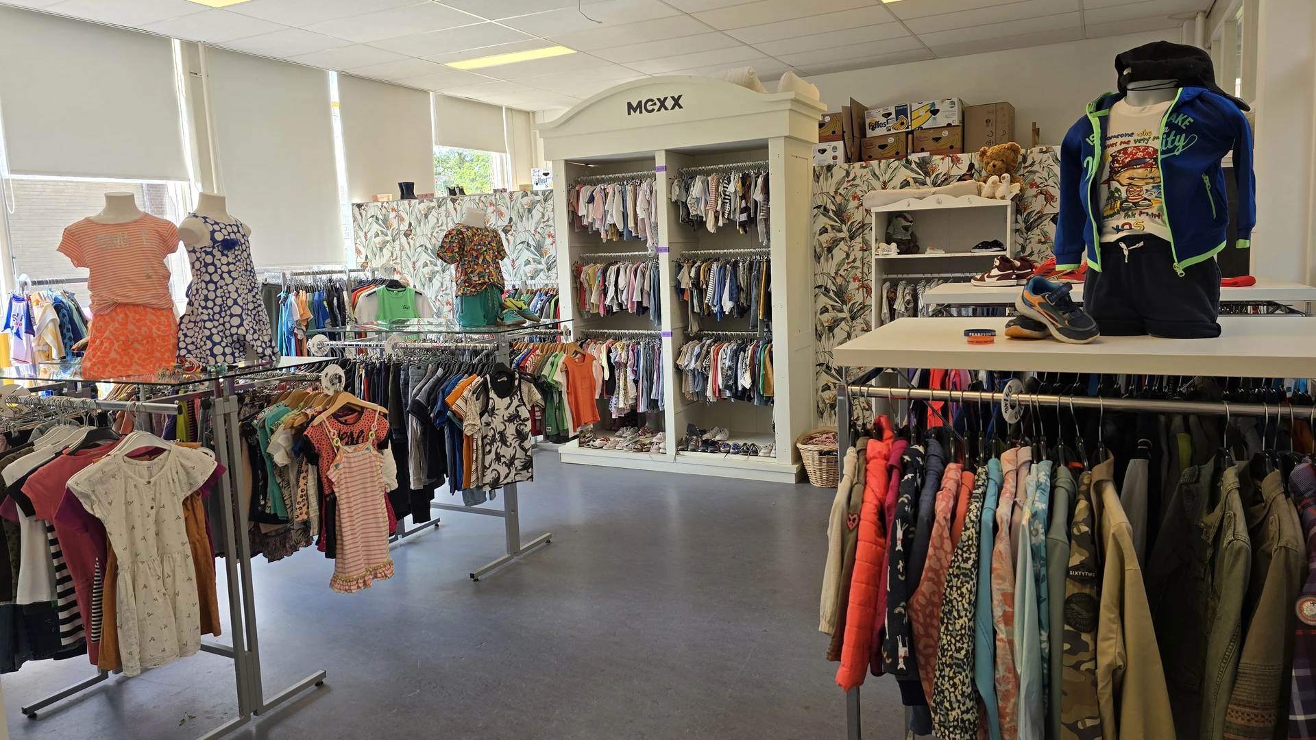 Winkelvloer met kledingrekken, stellingen en MEXX-display met tweedehands kleding