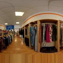 Winkelvloer met kledingrekken en houten kledingkasten vol tweedehands kleding