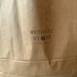 Papieren zak met opdruk 'RESHAPE STORE' en klein logo