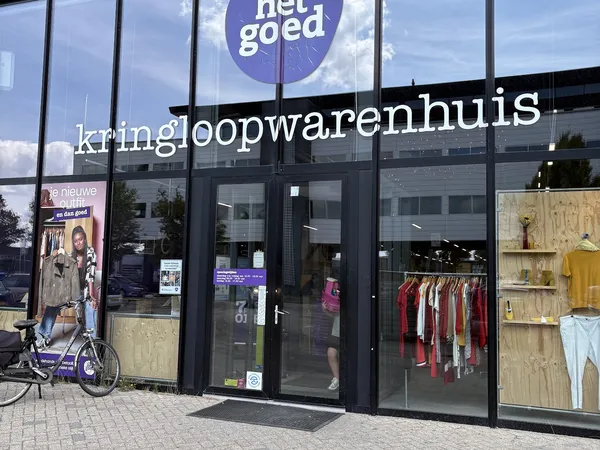 Gevel van kringloopwinkel met grote ramen, zwarte kozijnen en het logo 'het goed' bovenaan. Winkelnaam 'kringloopwarenhuis' i