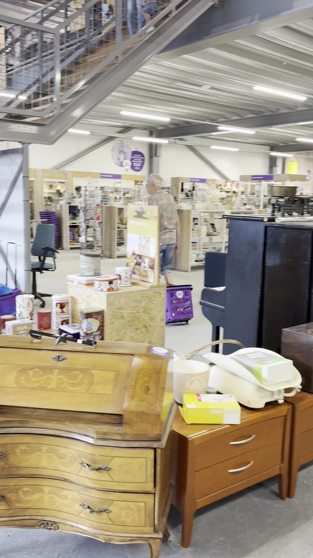 Winkelvloer met stellingen, toonbanken en diverse artikelen in een kringloopwinkel