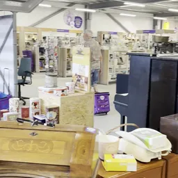 Winkelvloer met stellingen, toonbanken en diverse artikelen in een kringloopwinkel