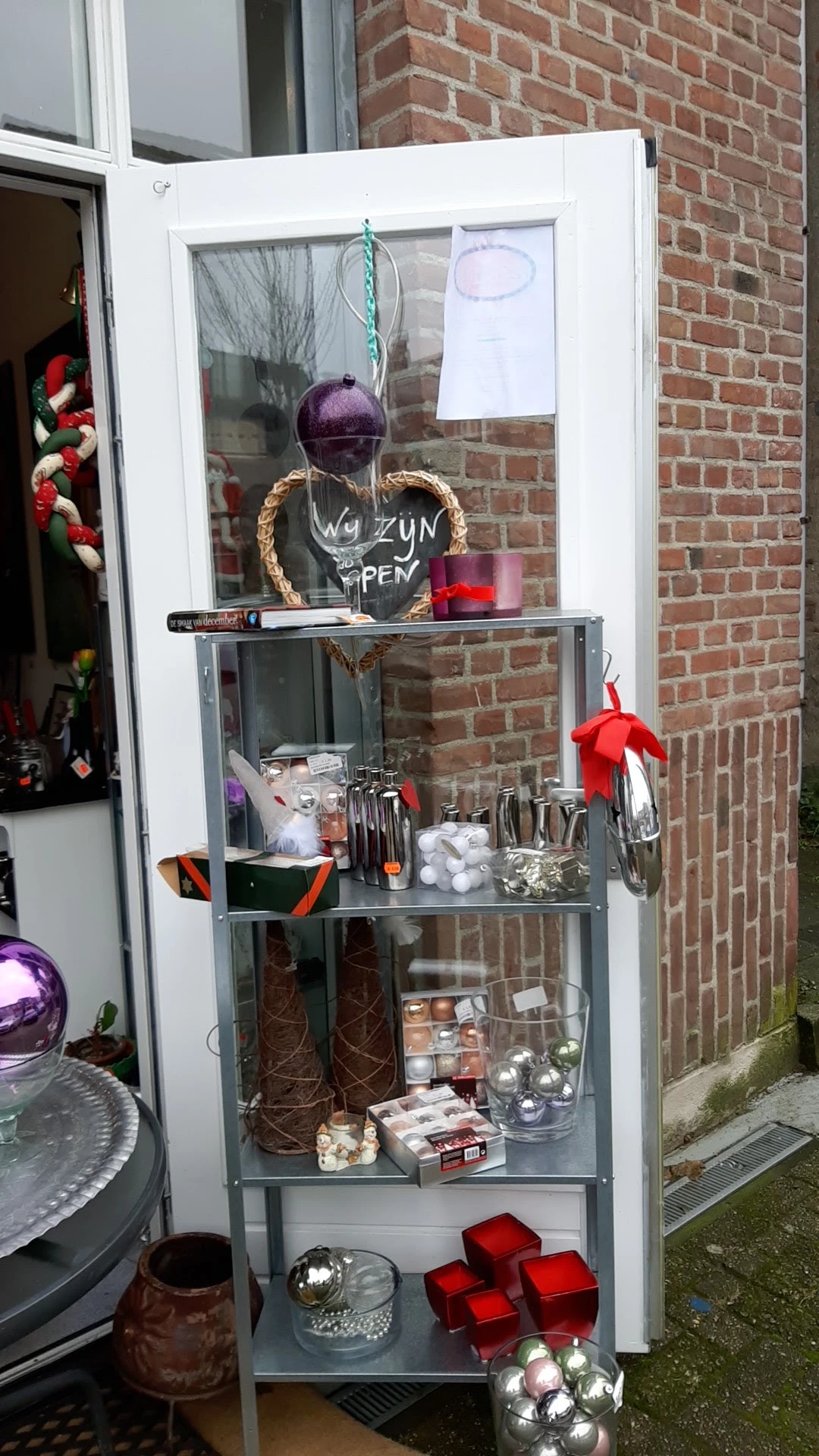Vitrinekast met decoratieve items en kerstversiering in een tweedehandswinkel