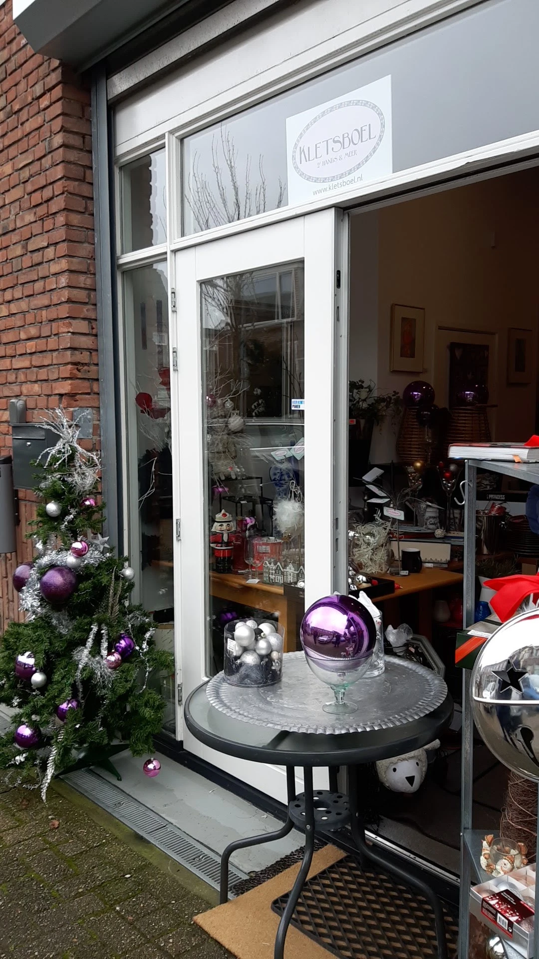 Winkelruit met kerstversiering en decoratieve items zoals paarse en zilveren kerstballen en takken