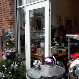 Winkelruit met kerstversiering en decoratieve items zoals paarse en zilveren kerstballen en takken