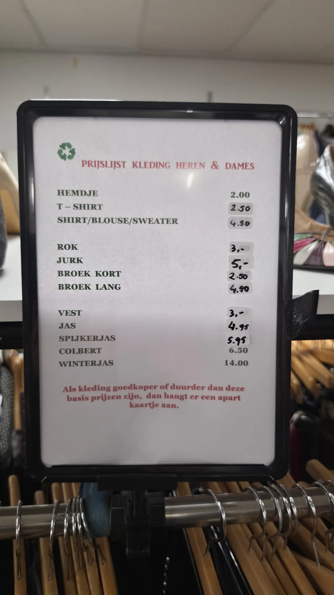 Menukaart met prijzen voor kledingstukken en winterjas van kringloop-koffiehuis