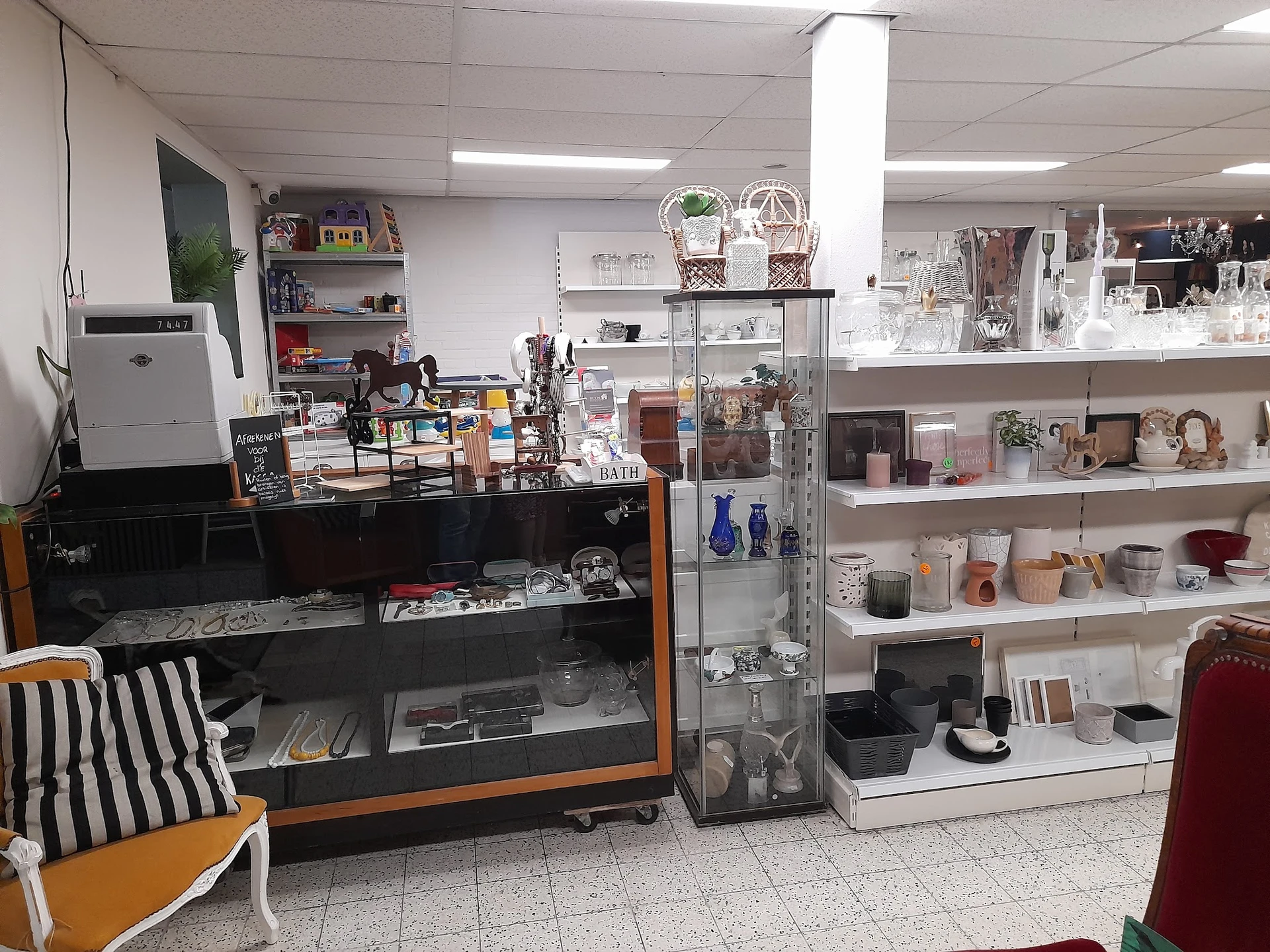 Winkelvloer met vitrinekast, stellingen met servies en decoratie, fauteuil en diverse kringloopwaar